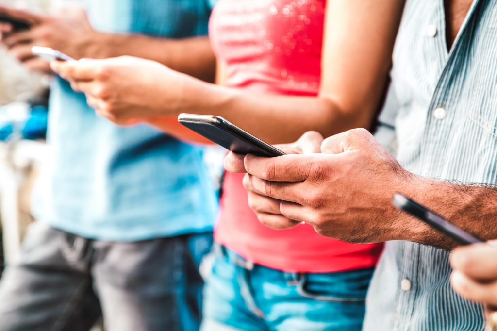persone al cellulare - Canva