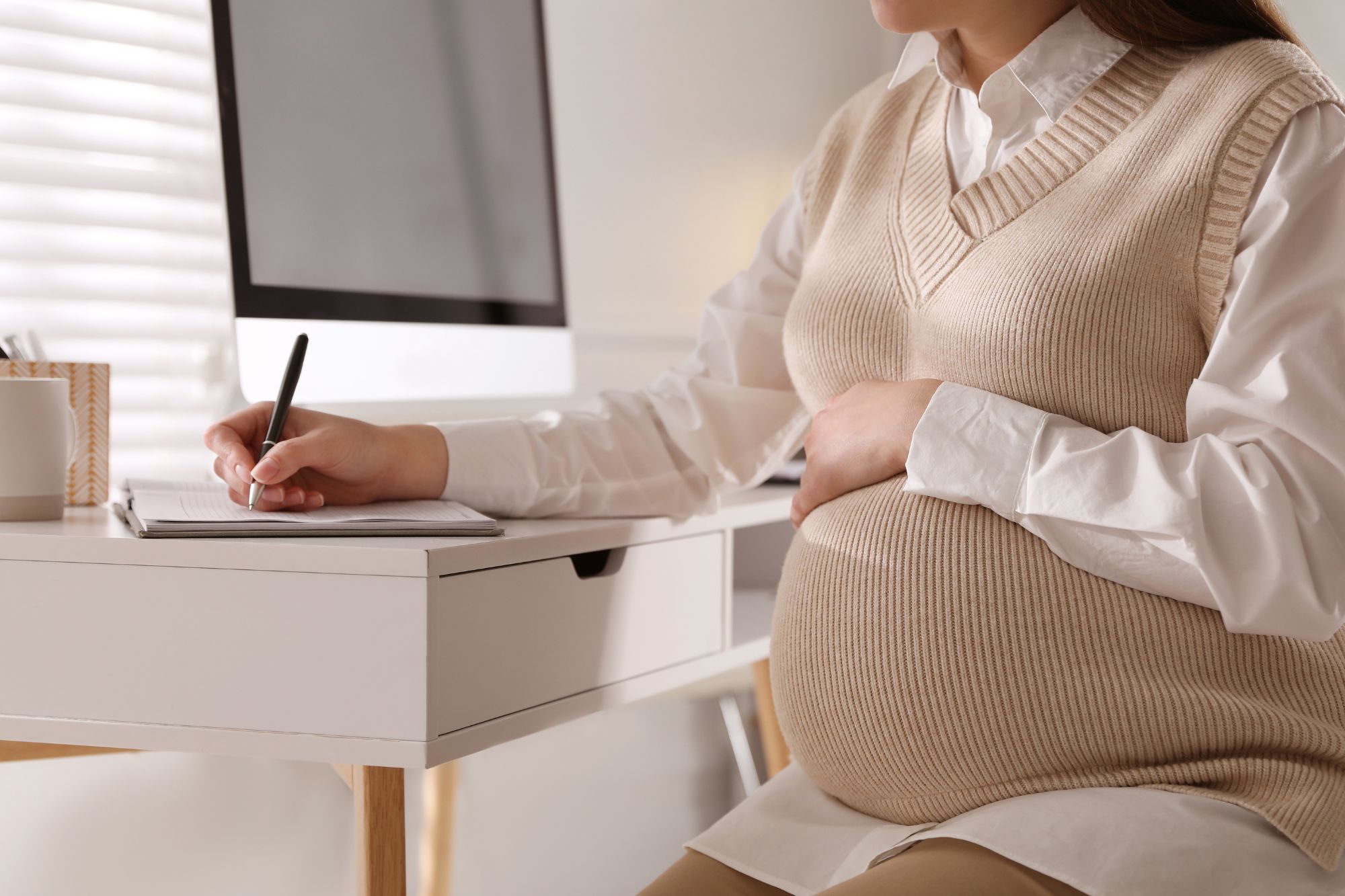 Donna incinta a lavoro - Canva