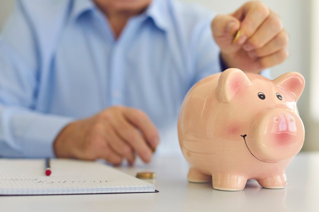 mette soldi nel salvadanaio a porcellino