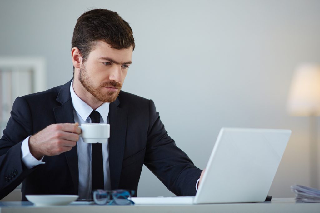 Bonus giovani under 35, giovane al lavoro al pc con tazza di caffè
