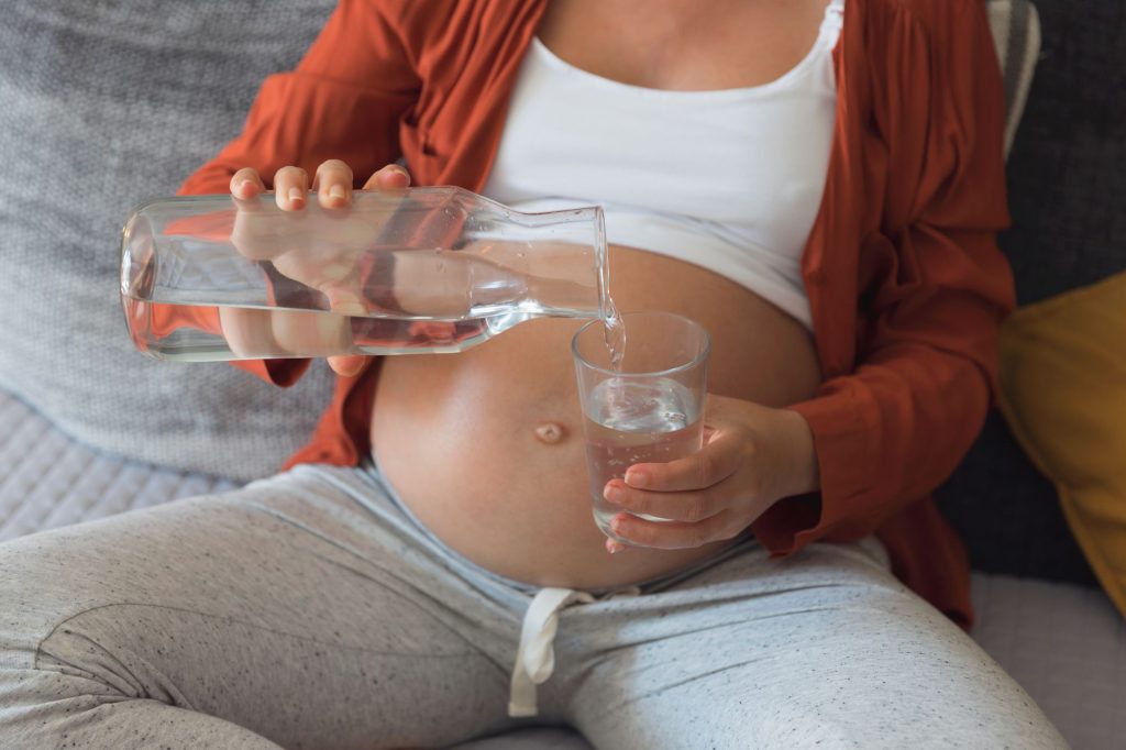 Una donna incinta beve acqua del rubinetto (Canva)