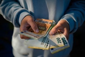 Soldi in mano a un ventenne - Canva